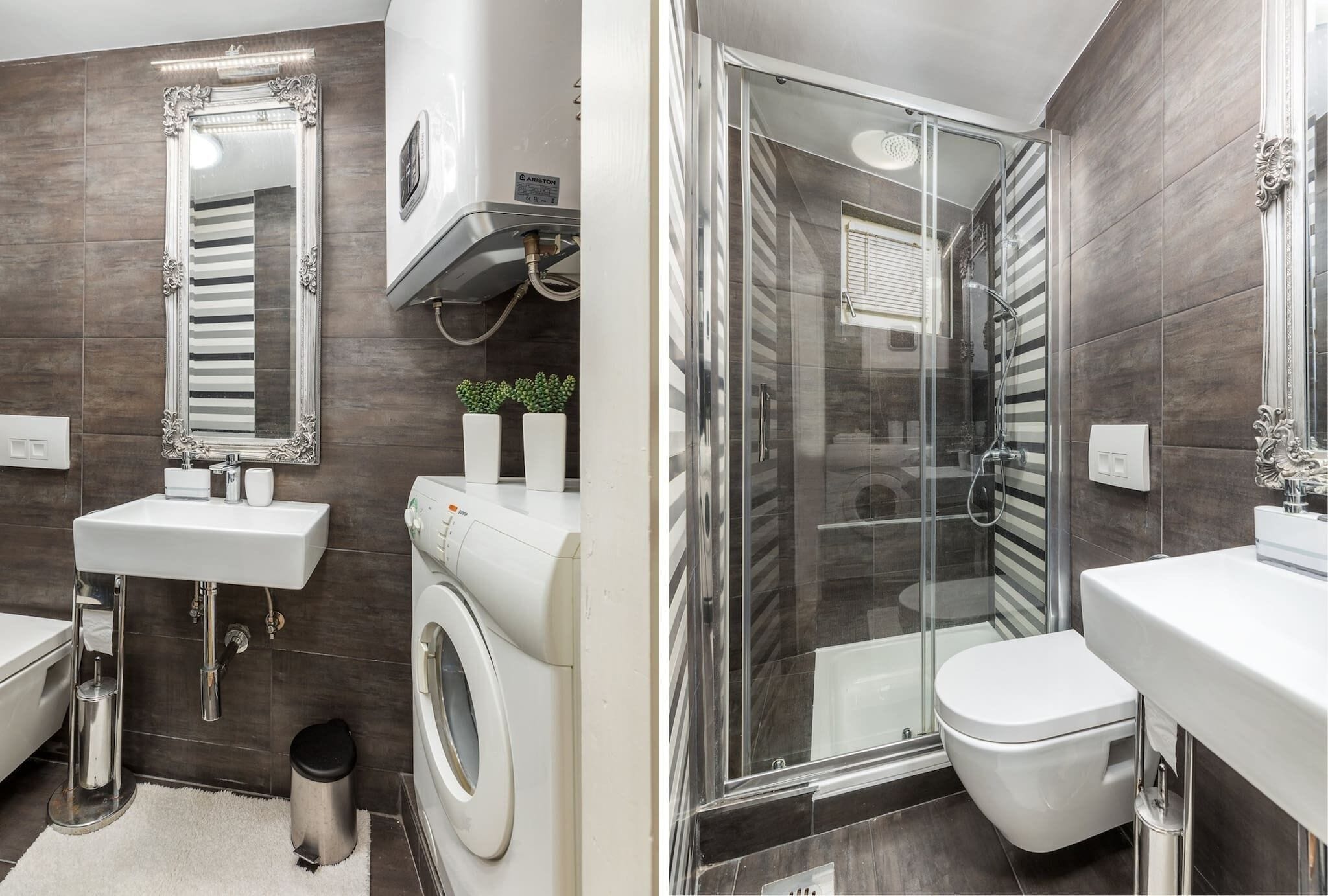 A modern bathroom with a large mirror, a sink, a washing machine, a toilet, and a glass-enclosed shower.