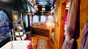A cozy train cabin with a bed, a small table, and a wooden bench. - Spend an evening w Trolley Parton! #Love #IndoorProjector #Vibes #Renew (Doyle)
