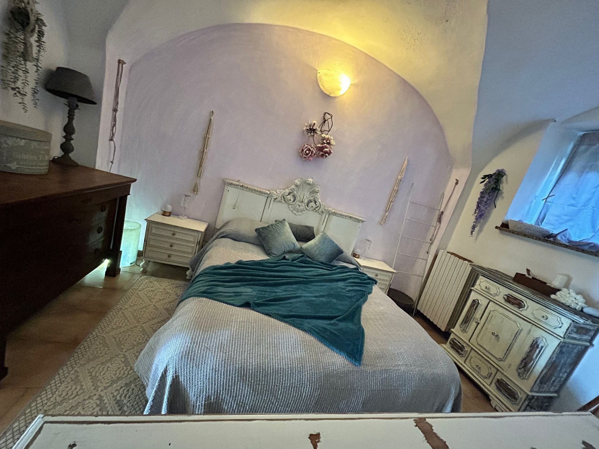 Ein Schlafzimmer mit Bett, Nachttischen, einem Schminktisch und einer Lampe.
