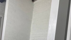 A corner of a room with white brick walls and a white door frame.