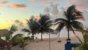 Blick auf ein Schwimmbecken mit Strand und Palmen.
