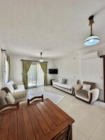 Apartamento económico, vistas al jardín | Zona de estar | Televisión LCD de 70 pulgadas con canales por satélite