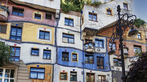 Un immeuble à plusieurs étages, doté de façades colorées et de balcons.