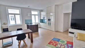Un appartement moderne comprenant un coin repas, une cuisine et un salon.