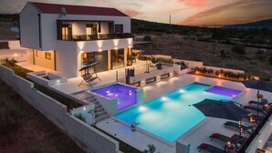 A modern two-story house with a swimming pool, outdoor seating, and a view of the landscape. - Villa Summer Dream - luxury and adventure by MyWaycation (Vrana)