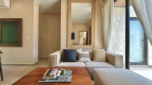 A modern living room with a sofa, a wooden coffee table, and a large mirror. - Bohemian Avant-garde 2BR Apartment (Tulum)