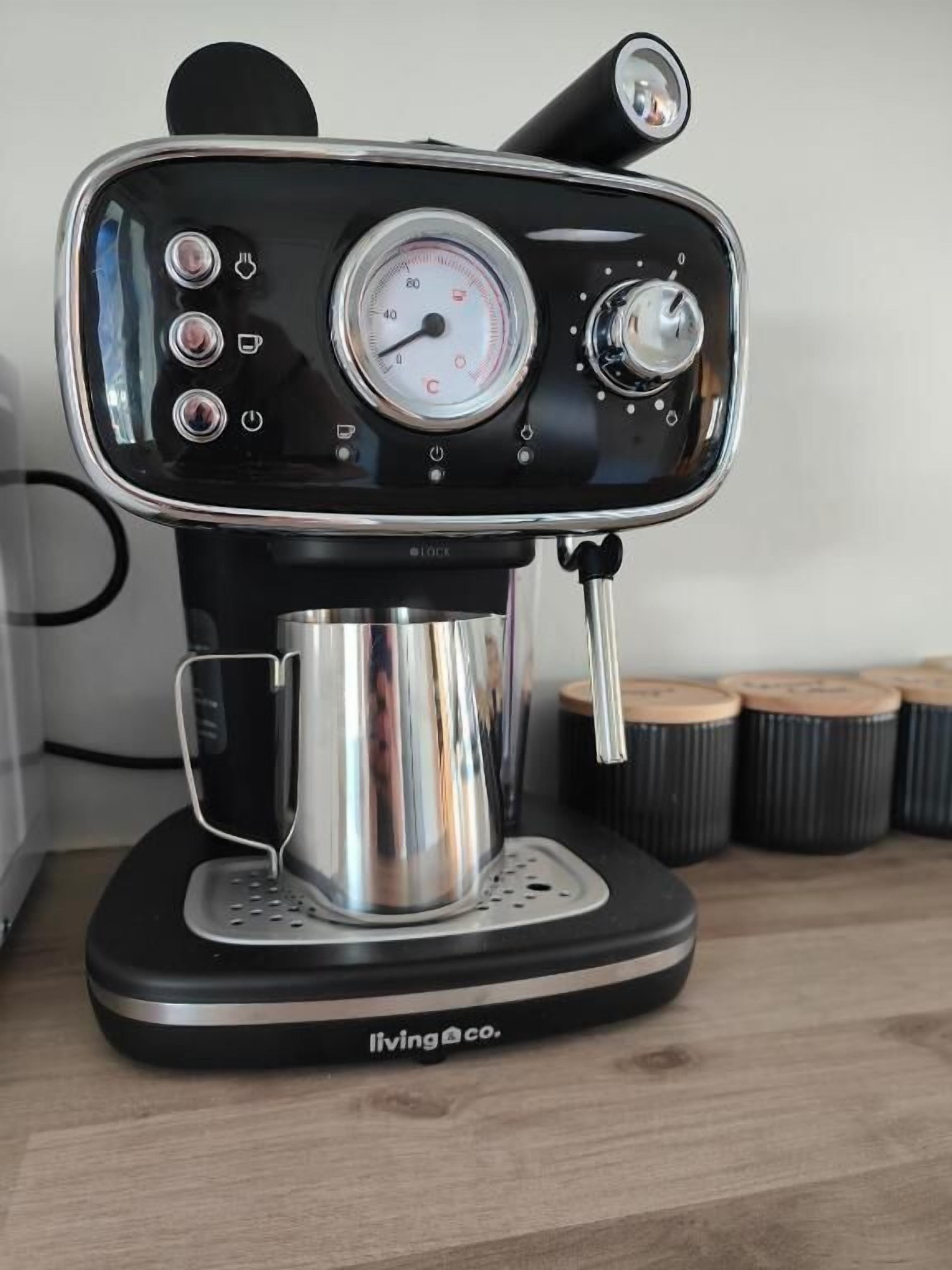 Una máquina de café con pantalla digital y panel de control, sobre una superficie de madera.
