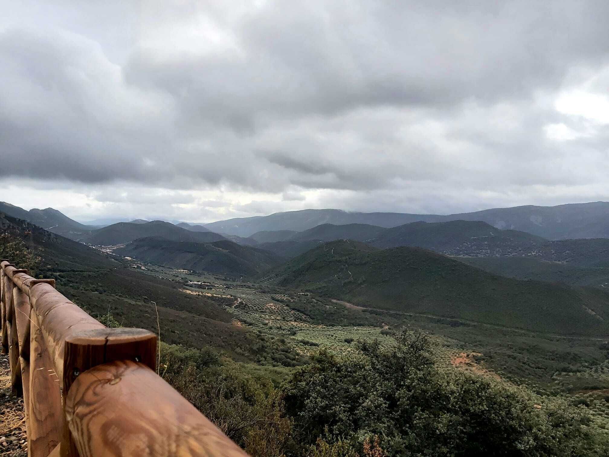 Paisaje montañoso con una valla de madera al frente.