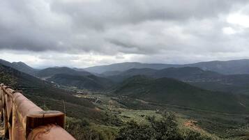 Paisaje montañoso con una valla de madera al frente.