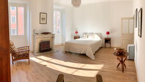 A bedroom with a bed, a fireplace, a chair, a table, and a radiator. - 3 bedroom cozy apartment in Ajaccio (Ajaccio)