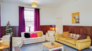 A living room with two sofas, a coffee table, and a Christmas tree. - 9 bedroom accommodation in Kirknewton, near Edinburgh (Kirknewton, near Edinburgh)