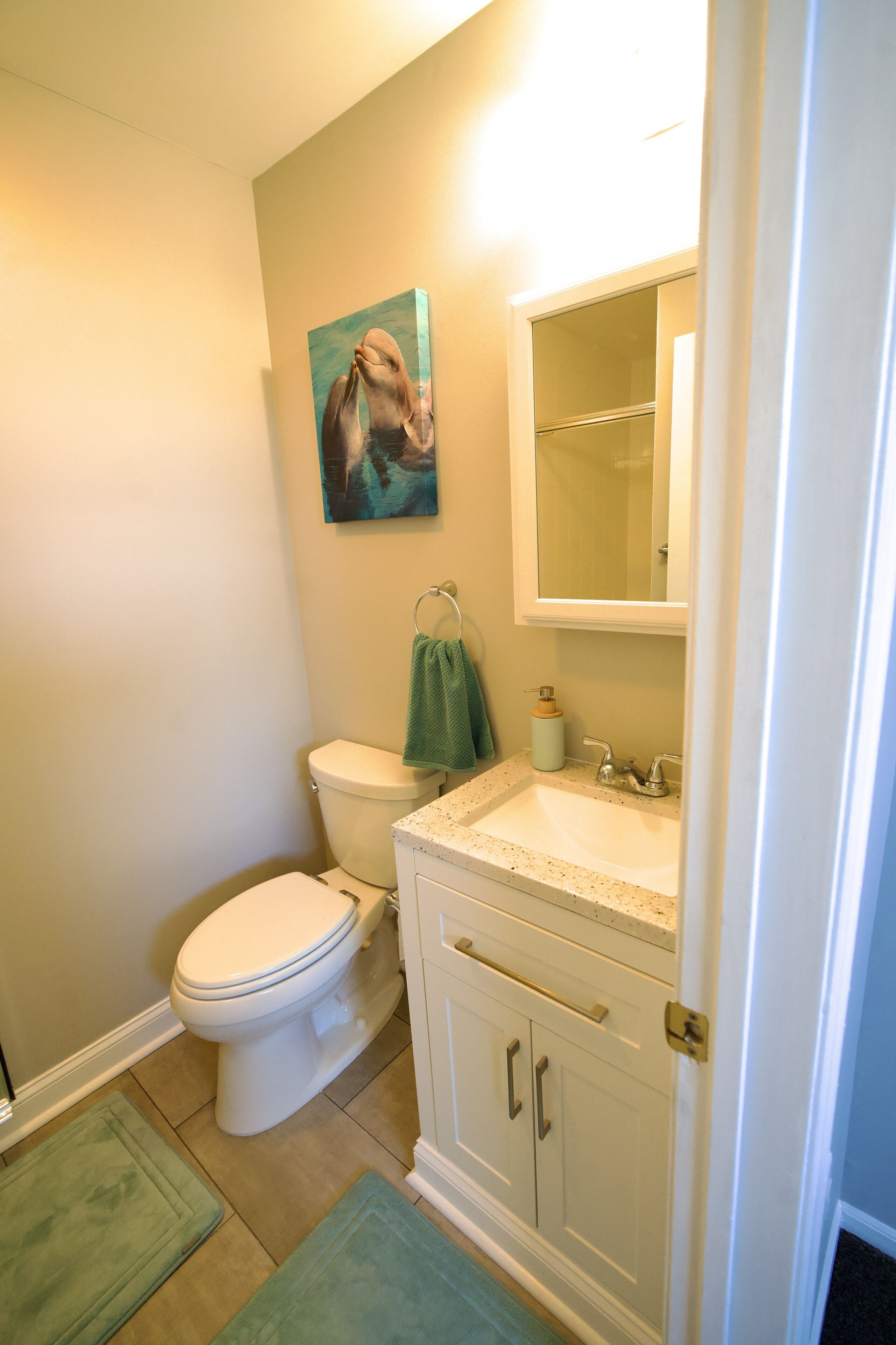 Ein Badezimmer mit Toilette, Waschbecken, Schrank und einem Bild an der Wand.