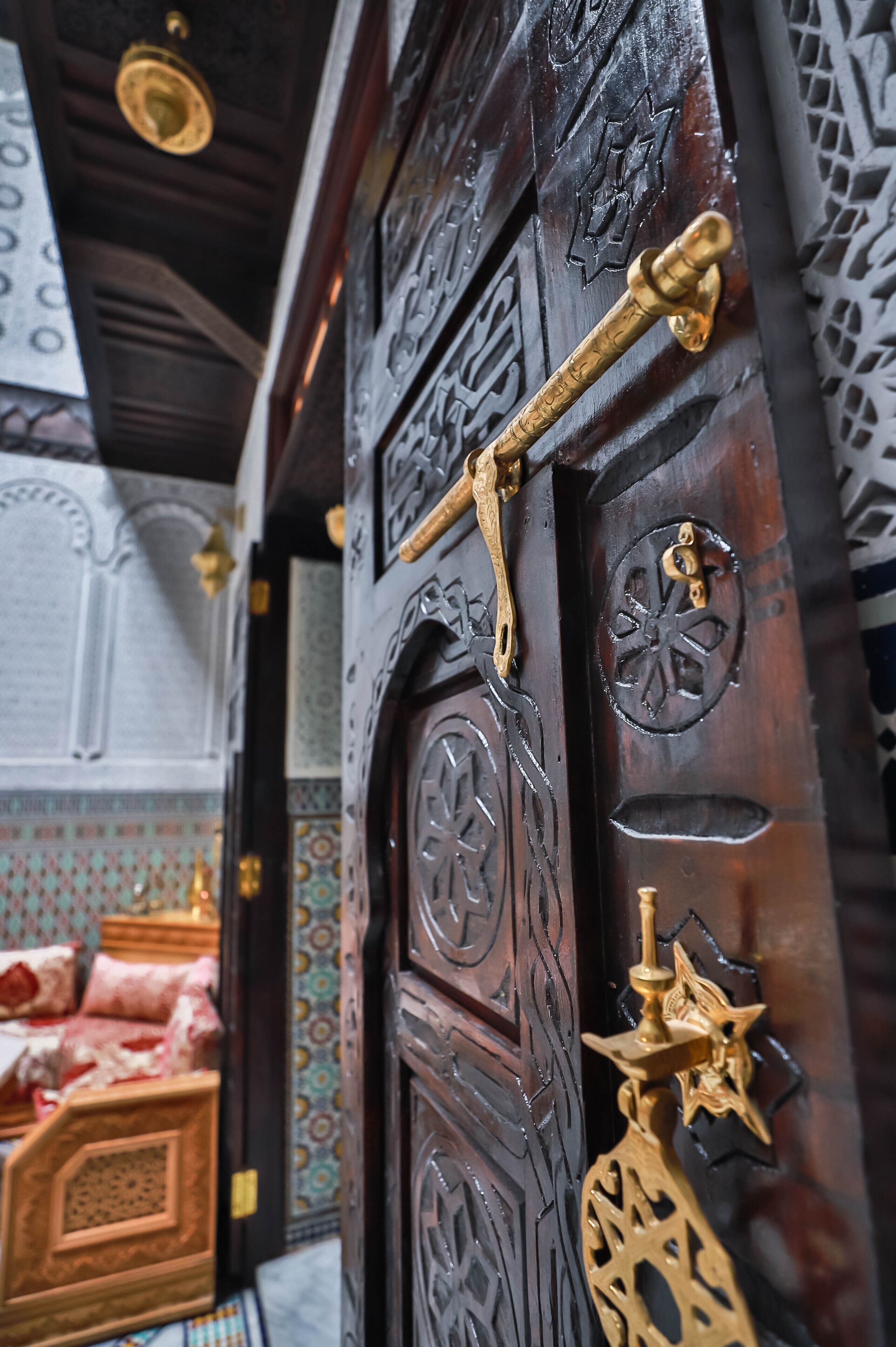 A wooden door with intricate carvings and a brass handle.