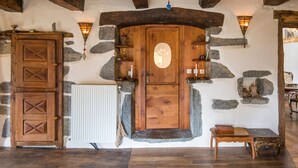 A rustic interior with a wooden door, stone walls, and a stone fireplace. - GiteleCun (Frayssinhes)
