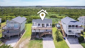 A beachfront property with three multi-story houses, each featuring balconies and outdoor seating areas. - 5951- South Of Stars - South Nags Head Escape w/ Pool & Hot Tub (Nags Head)