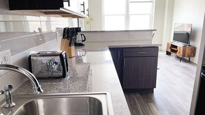 Eine moderne Küche mit Spüle aus Edelstahl, einem Toaster und einer Kaffeemaschine.