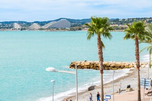 A coastal view with a beach, palm trees, and a large cruise ship in the background. - Apartment Angelina with Sea View, Private Terrace and Wi-Fi (cagnes-sur-mer)