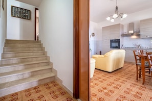 A staircase leading to a living area with a sofa and a dining table.