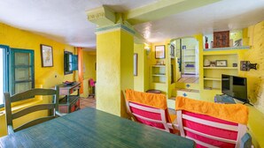 A dining area with a table, chairs, and a yellow wall.