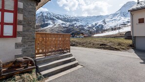 A stone building with a wooden bench outside, a wooden fence, and a mountain view. - Apartment "Albiez Montrond" with Mountain View, Balcony and Wi-Fi (Albiez-Montrond)