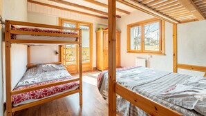A room with a bunk bed, wooden beams, a window, and a view of the outside. - Apartment "Albiez Montrond" with Mountain View, Balcony and Wi-Fi (Albiez-Montrond)