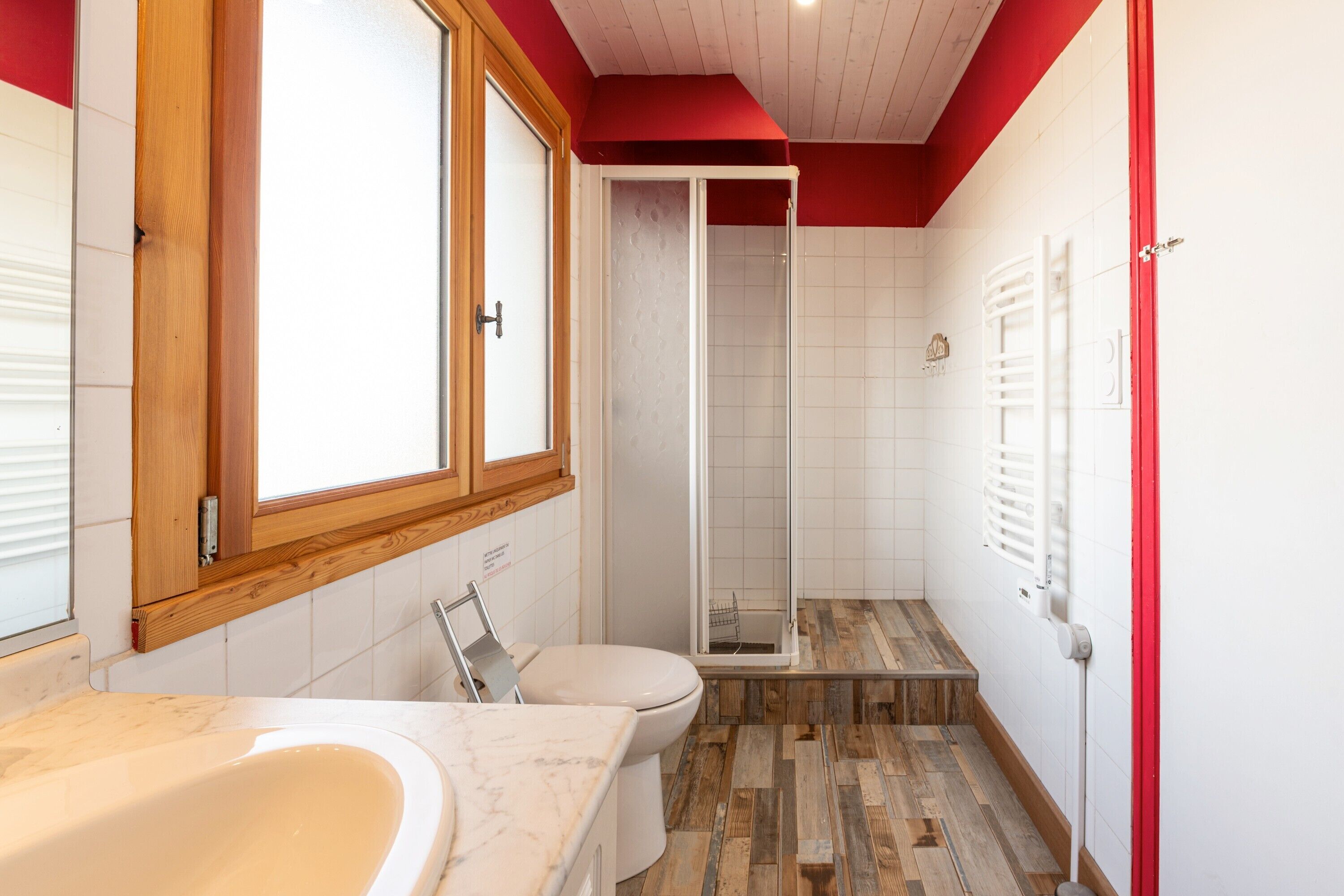 A bathroom with a bathtub, toilet, and shower area.