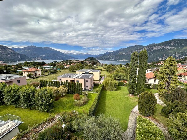A residential area with houses, a well-maintained garden, and a lake view.