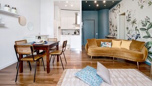 A modern living space with a dining area, a sofa, and a kitchen in the background. - Apartment 'Historia Suite Bellagio' with Lake View, Shared Garden and Wi-Fi (Bellagio)