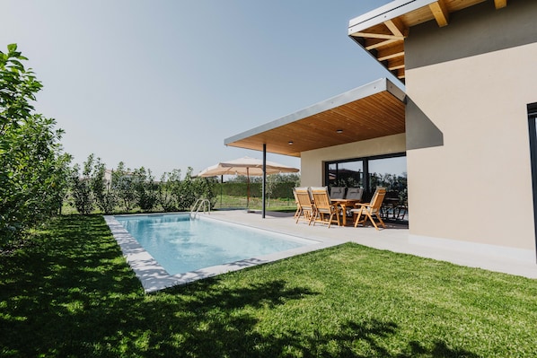 A modern house with a swimming pool, outdoor seating, and a covered patio. - Villa 'Luxe Maxime' with Private Pool, Wi-Fi and Air Conditioning (Lazise)