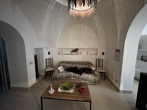 Ein modernes Wohnzimmer mit einer Couch, einem Couchtisch und einer Pendelleuchte.