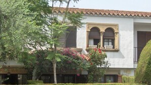 A building with a white facade, arched windows, and a tiled roof. - Holiday Home 'Villa Consuelo' with Shared Pool, Private Terrace and Private Garden (Cambrils)
