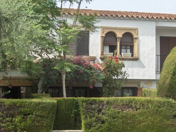A building with a white facade, arched windows, and a tiled roof.