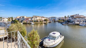 A marina with boats docked, a clear sky, and buildings with a Mediterranean architectural style. - 'Petite Maison Aigues Mortes' with Sea View, Shared Pool and Wi-Fi (Aigues-Mortes)