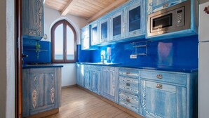Una cocina con armarios azules, un microondas y una estufa.