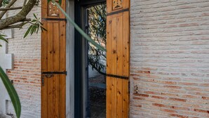 A wooden door with a metal latch, set in a brick wall.