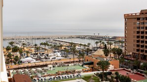 A marina with boats, a pool area with sun loungers, and a building with balconies. - Apartment In A Hotel 'Marina View, Sunny One Bedroom Pyr' with Shared Pool and Air Conditioning (Fuengirola)