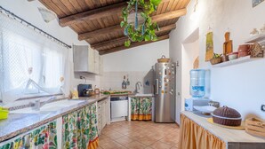 A kitchen with a wooden ceiling, a sink, a refrigerator, and a water dispenser. - Apartment "Sara Home" with Sea View, Private Terrace & Wi-Fi (Portopalo di Capo Passero)