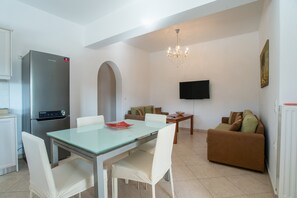 A modern living space with a dining area, kitchen, and seating area.