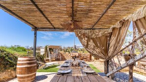 An outdoor dining area with a wooden table set for a meal, a pergola overhead, and a stone patio. - 'Villa Sunrise' with Shared Terrace, Wi-Fi, and AC – Ideal for 4/5 Adults and 1 Child (Gallipoli)