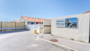 A gated entrance with a sign for 'Residence Edenplage,' a paved area, and a building with a red-tiled roof. - Naturist holiday home 'Résidence Naturiste Eden' with sea view, private terrace, and Wi-Fi (Leucate)