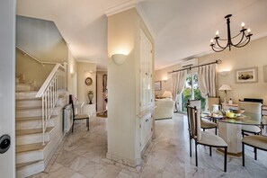 A spacious living area with a staircase, a dining table with chairs, and a chandelier. - Villa "Mng Elliott 52" with Private Pool and Wi-Fi (Vale do Lobo)
