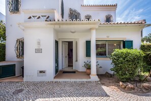 A white building with a tiled roof, a number plaque, and a potted plant. - Villa "Mng Elliott 50" with Private Pool & Wi-Fi (Vale do Lobo)