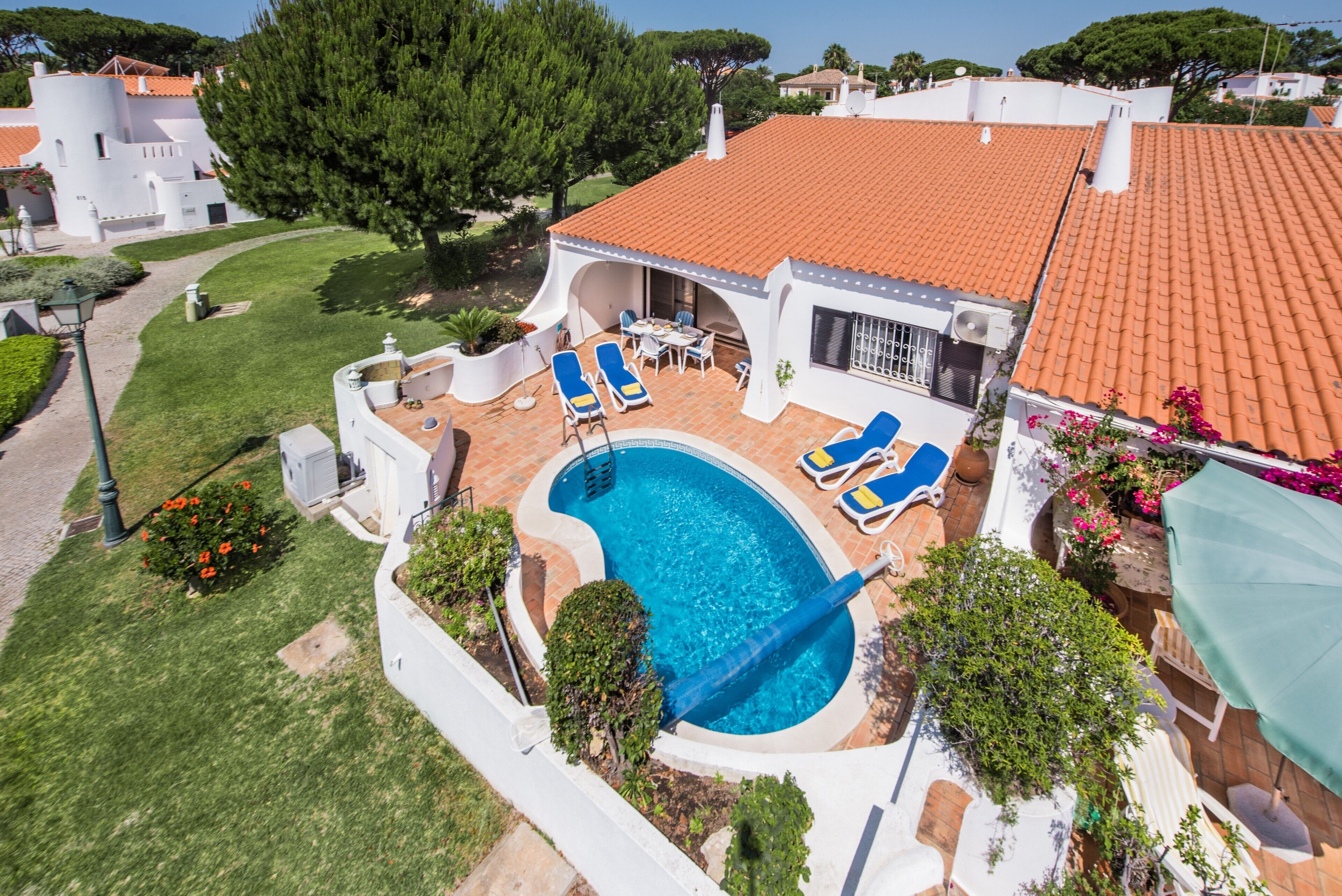 En boligejendom med swimmingpool, liggestole og en terrasse.