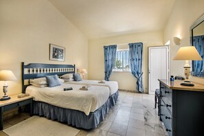 Une chambre avec deux lits, une commode, une table de chevet, une fenêtre avec des rideaux et un tableau encadré au mur.