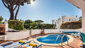 A pool area with lounge chairs, a swimming pool, and a white building in the background. - Villa "Mng Elliott 74" with Private Pool and Wi-Fi (Vale do Lobo)