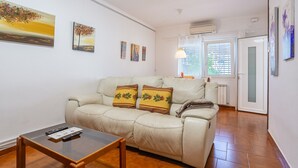 Ein Wohnzimmer mit einer Couch, einem kleinen Tisch und Kunstwerken an den Wänden.