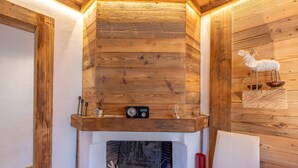 A wooden interior with a fireplace, a radio, and a decorative deer sculpture.