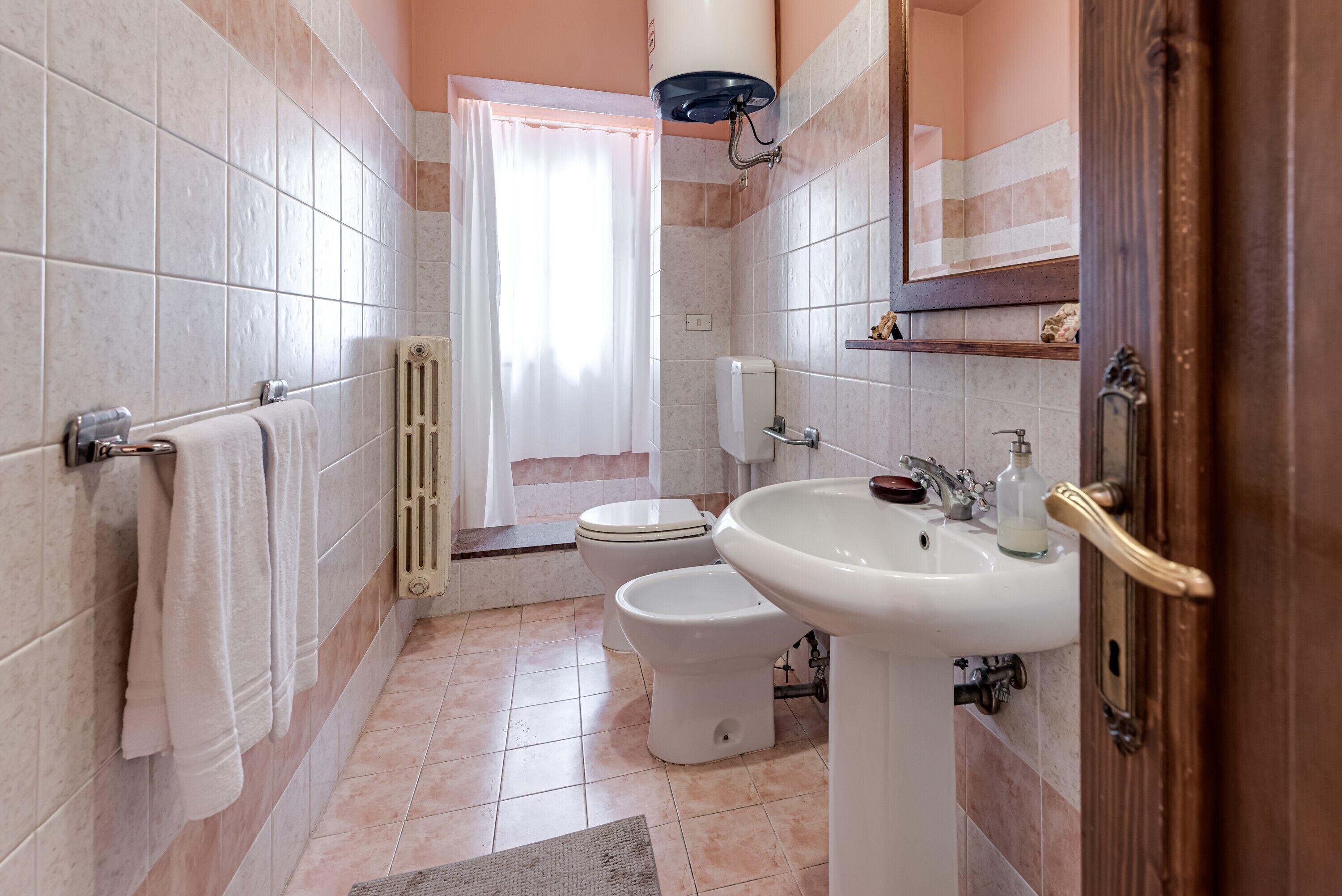 Un bagno con il water, lavandino e zona doccia.