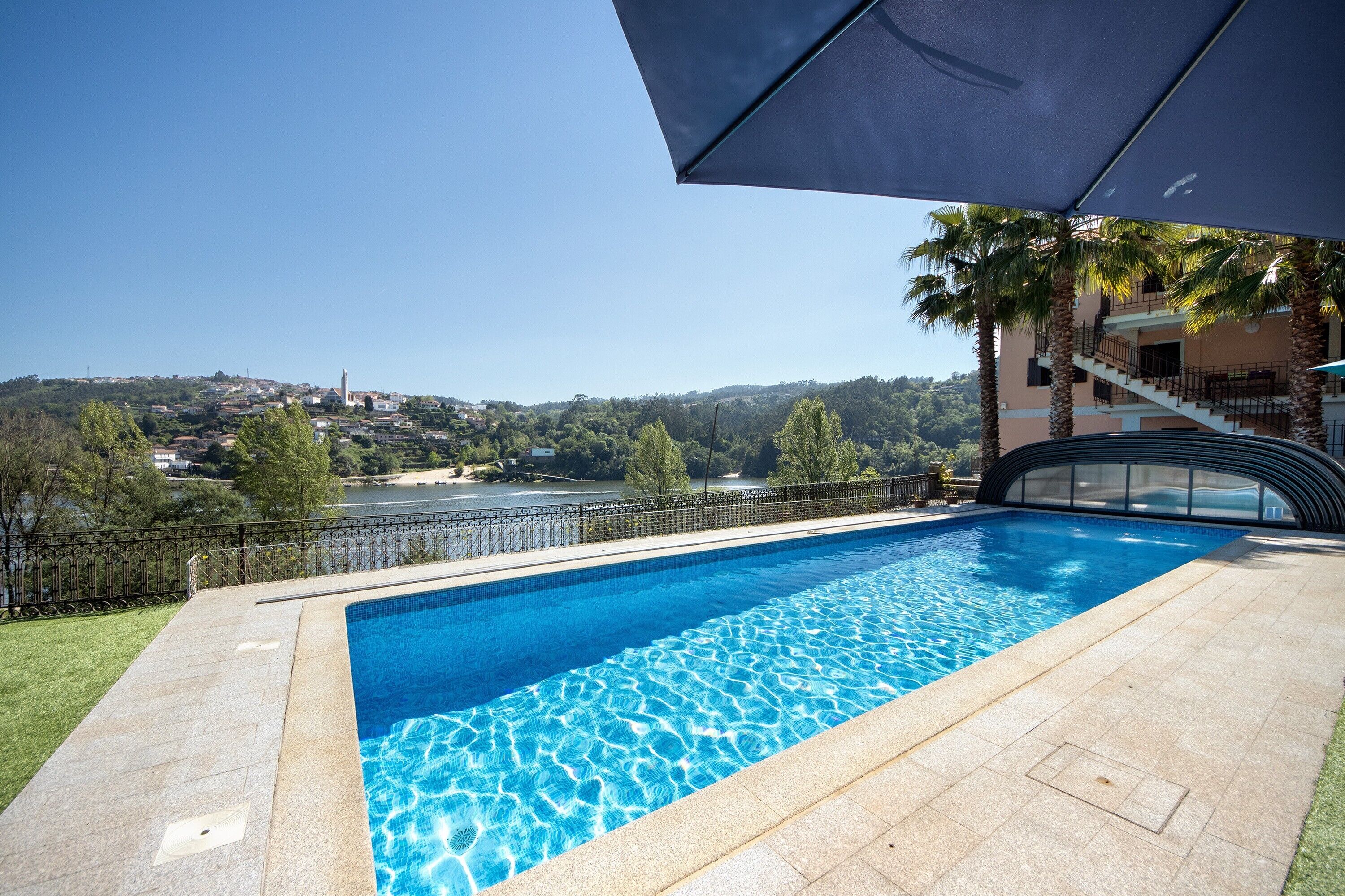 Una piscina con vistas a una colina y una masa de agua.