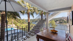 A balcony with a pool, palm trees, and a view of a town. - Holiday Home 'Porto Douro' with Private and Indoor Pools, Heated Water, Terrace and Wi-Fi (Foz do Sousa)